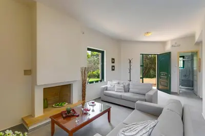 a living room with a couch and a fireplace at Villa Ilos by Villa Plus in Pírgos Psilonérou