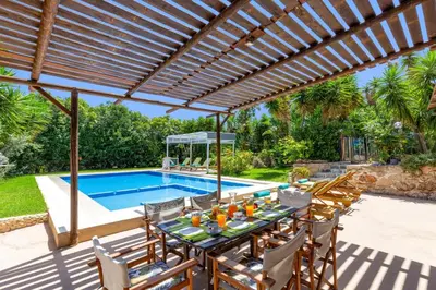 a patio with a table and chairs and a swimming pool at Villa Liostasi by Villa Plus in Agia Marina Nea Kydonias