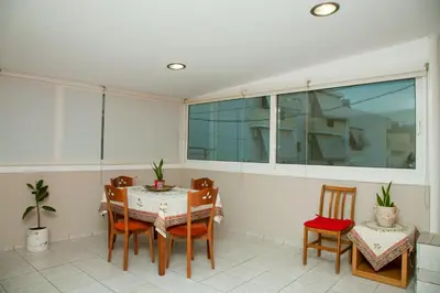 a dining room with a table and chairs and a window at Georgia's House Chania in Chania Town