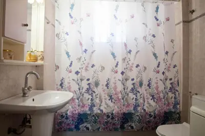 a bathroom with a sink and a shower curtain with flowers at Georgia's House Chania in Chania Town