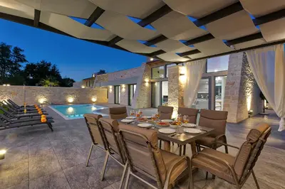 a patio with a table and chairs and a pool at Villa Potami Angela by Villa Plus in Stílos