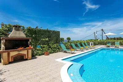 an outdoor swimming pool with a fireplace next to a swimming pool at Villa Katerina Pente by Villa Plus in Kalyves