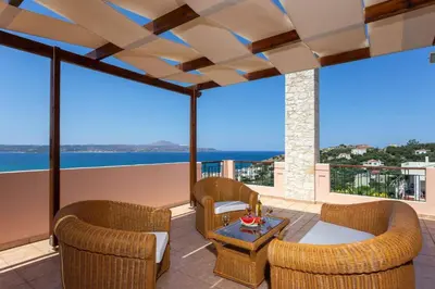 a patio with wicker chairs and a table at Villa Margarita Exi by Villa Plus in Kalyves