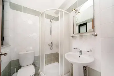a white bathroom with a toilet and a sink at Villa Margarita Exi by Villa Plus in Kalyves