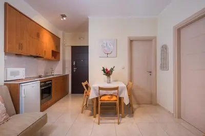 a kitchen and dining room with a table and chairs at Luxury Coastal Retreat, Mountain View Balcony with Palm Trees & Parking in Chania Town