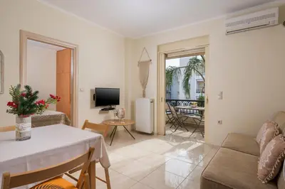 a living room with a couch and a table at Luxury Coastal Retreat, Mountain View Balcony with Palm Trees & Parking in Chania Town