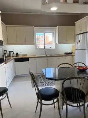 a kitchen with white cabinets and a table and chairs at Christina_Apt in Chania Town