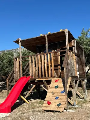 a wooden play structure with a slide and a slideintend at Villa Ciel in Agios Padeleimon