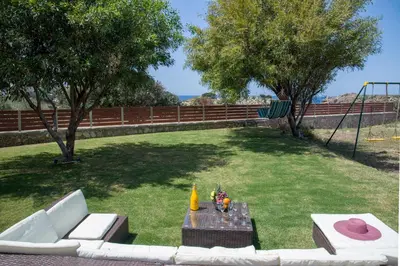 a garden with a couch and a table in the grass at Villa Ciel in Agios Padeleimon