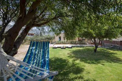 a blue hammock sitting under a tree in a yard at Villa Ciel in Agios Padeleimon