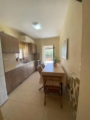 a kitchen with a table and chairs in a room at Koundouros Home in AmigdhalokeFálion