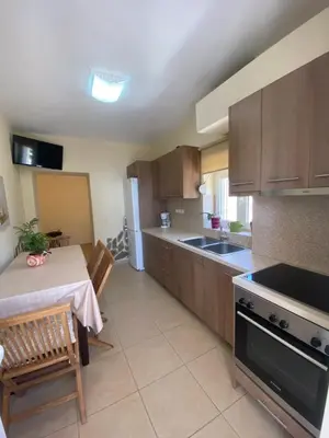 a kitchen with a table and a stove top oven at Koundouros Home in AmigdhalokeFálion