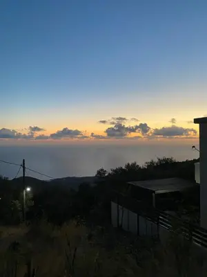 a view of the ocean at sunset from a house at Koundouros Home in AmigdhalokeFálion