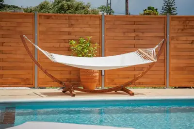 a hammock sitting next to a swimming pool at Avocado Villas in Chania Town