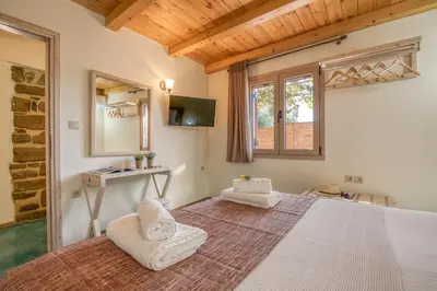 a bedroom with a large bed and a mirror at Avocado Villas in Chania Town