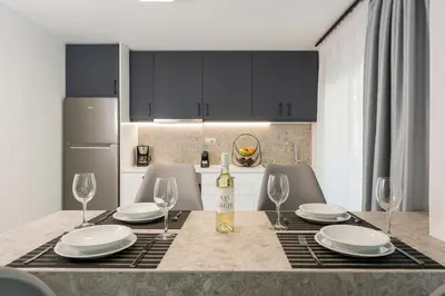 a kitchen with a table with glasses and a bottle of wine at Quarters Luxury Apts in Chania Town