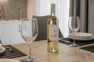 a bottle of wine sitting on a table with two wine glasses at Quarters Luxury Apts in Chania Town