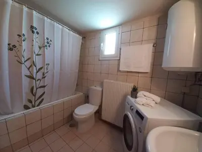 a bathroom with a toilet sink and a washing machine at Casa Constans in Maleme
