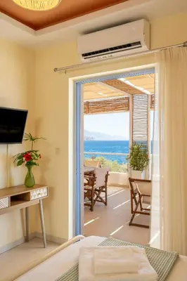 a bedroom with a view of the ocean at Aris Apartment in Palaiochóra