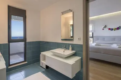 a bathroom with a sink and a bedroom with a bed at Luxury Villas near The Sea With Heated Pool in Kato Daratso