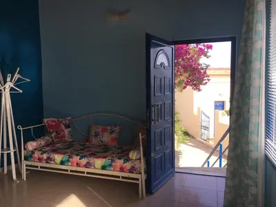 a blue room with a bed and a door at Great sea-view apartment. in Khóra Sfakíon
