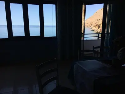 a room with windows and a view of the ocean at Great sea-view apartment. in Khóra Sfakíon