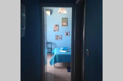 a room with a bed and a blue wall at Great sea-view apartment. in Khóra Sfakíon
