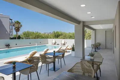 a patio with tables and chairs and a swimming pool at Kallistefan in Kissamos