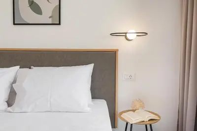 a bedroom with a bed with a lamp and a book at Kallistefan in Kissamos