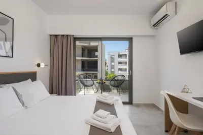 a bedroom with a bed with a desk and a balcony at Kallistefan in Kissamos
