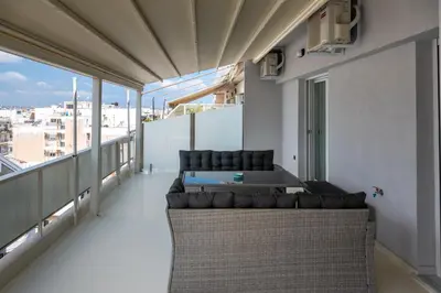 a living room with a couch and a table on a balcony at CENTRAL ROOF NK CHANIA in Chania Town