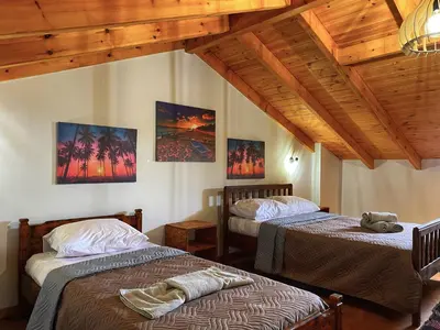 two beds in a room with wooden ceilings at DESTAN & JULIETTE SEA VIEW Villa in Kamisianá