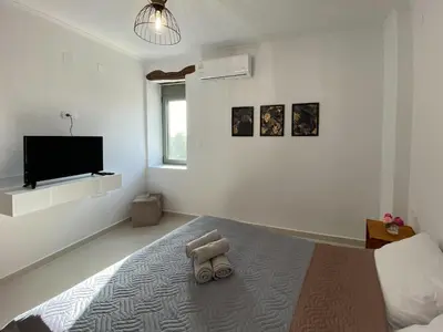 a bedroom with a bed with a teddy bear on it at DESTAN & JULIETTE SEA VIEW Villa in Kamisianá