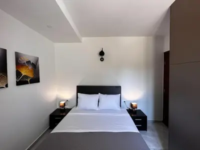 a bedroom with a large bed with two night stands at DESTAN & JULIETTE SEA VIEW Villa in Kamisianá