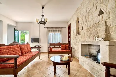 a living room with a couch and a fireplace at Villa Elia by PosarelliVillas in Vryses
