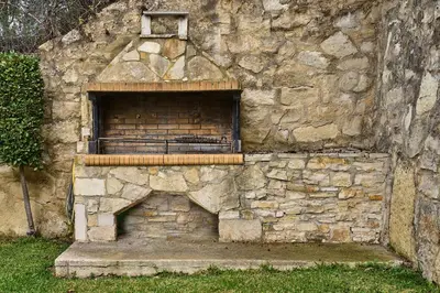 a stone wall with a brick oven with a window at Villa Elia by PosarelliVillas in Vryses