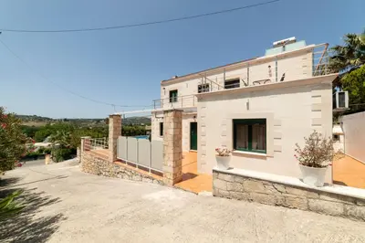 a large white house with a stone facade at Villa Elia by PosarelliVillas in Vryses