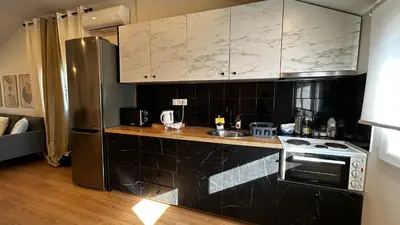 a kitchen with a stove and a refrigerator at Άνετο και πολυτελές οροφοδιαμέρισμα 2 in Chania Town