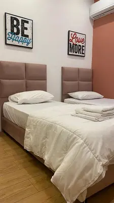 two beds sitting next to each other in a bedroom at Άνετο και πολυτελές οροφοδιαμέρισμα 2 in Chania Town