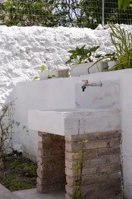 a white sink sitting on top of a brick wall at Jasmine Home by the Sea by 8essentially in Kalyves