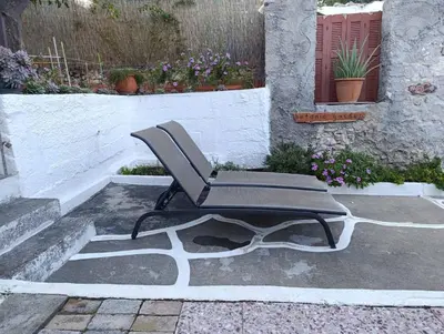 a chair sitting on the ground next to a building at Jasmine Home by the Sea by 8essentially in Kalyves