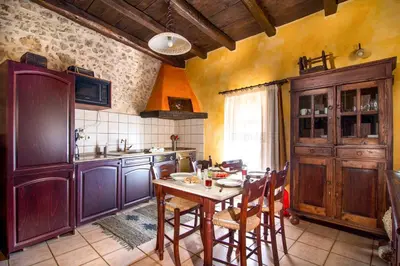 a kitchen with a wooden table in a room at Samonas - Orange villa Diktamos in Khiliomoudhoú