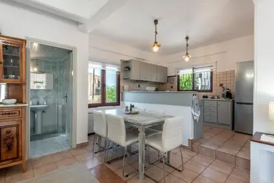 a kitchen with a table and chairs in a kitchen at ApteraMare Tradidtional house 'New listing' in Chania Town