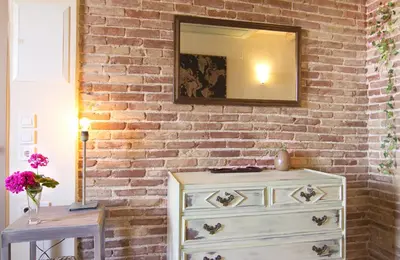 a brick wall with a mirror and a dresser at Auntie's home by Chania Old Harbor in Chania Town