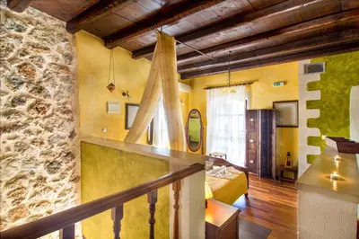 a room with a bed and a stone wall at Samonas - Green villa Faskomilia in Chania Town
