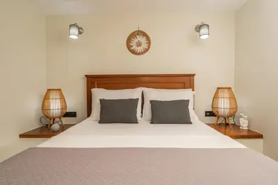 a bedroom with a bed with two lamps and a clock at Casa dei Sogni in Nerokoúros