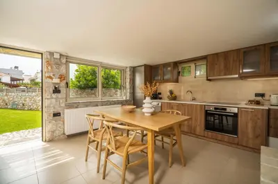 a kitchen with a wooden table and chairs at Casa dei Sogni in Nerokoúros