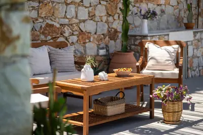 a wooden table and a chair on a patio at Casa dei Sogni in Nerokoúros