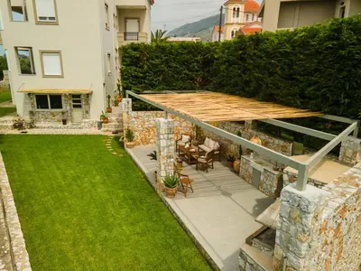 a backyard with a wooden deck and a lawn at Casa dei Sogni in Nerokoúros