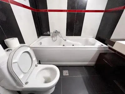 a bathroom with a white toilet and a bath tub at Central apartment in quiet neighborhood near sandy beach in Chania Town